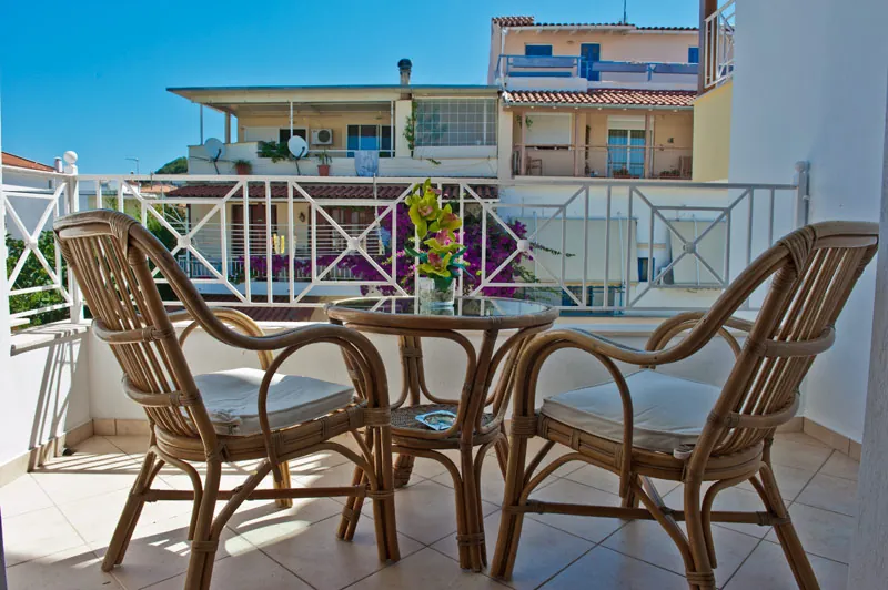 Cane chairs on a balcony above the neighbouring rooftops