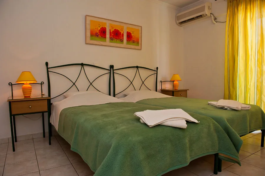 Twin beds with green covers in a studio