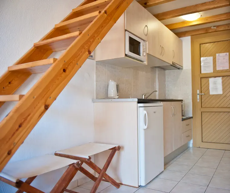 Kitchenette with microwave and fridge under the loft stairs