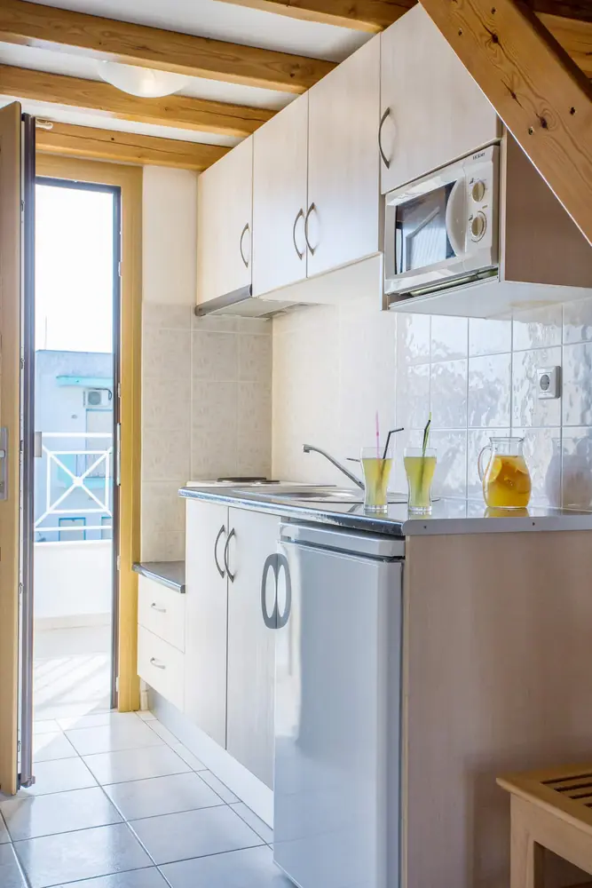 The kitchenette with its microwave beside the balcony door