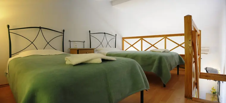 Beds beneath the wooden loft railing